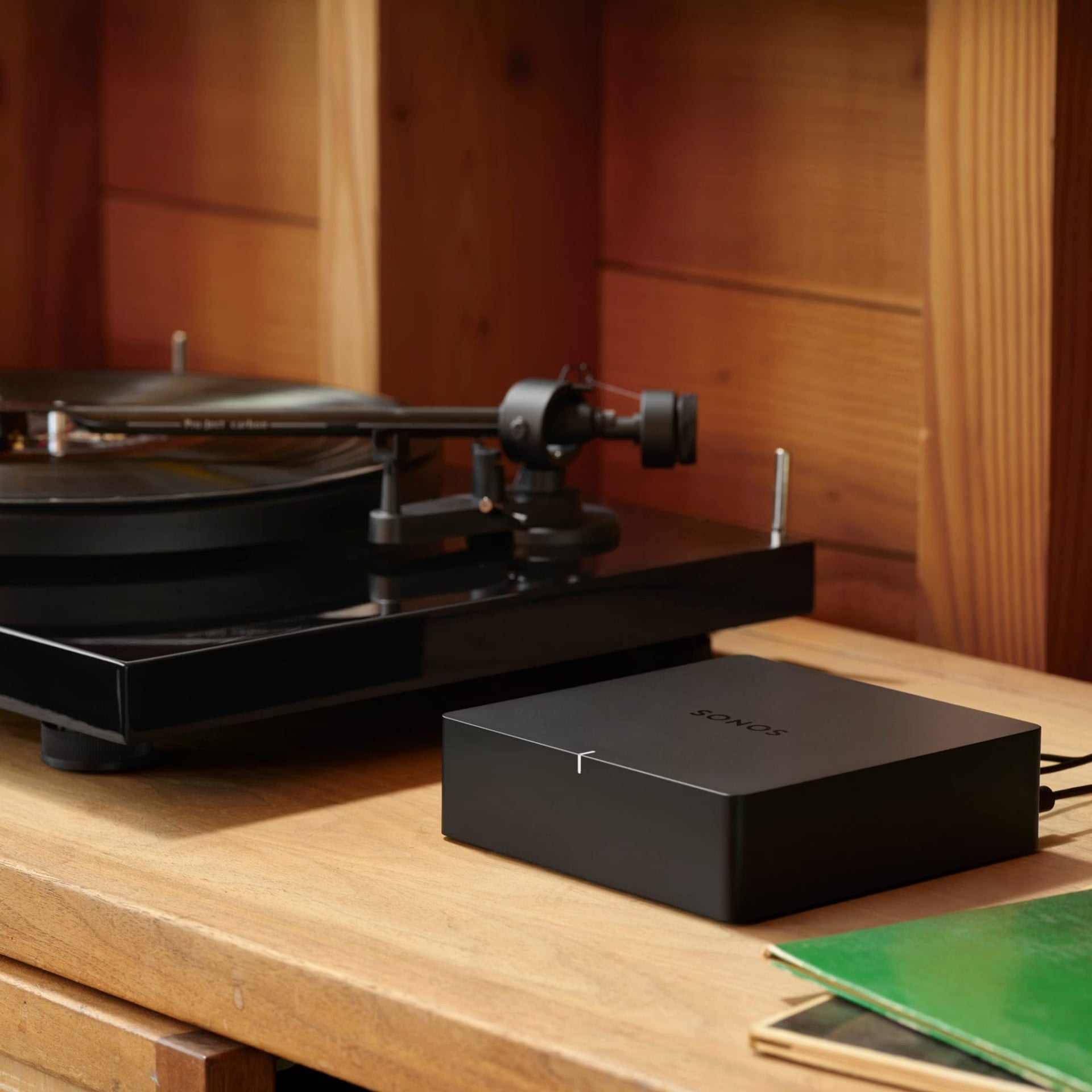 Sonos Port black on shelf beside hi-fi separates bringing Sonos multi-room audio to any system