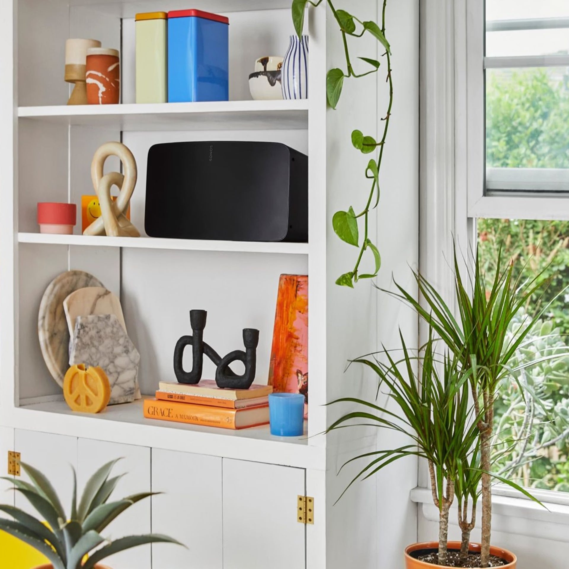 Person relaxing with Sonos Five black loudspeaker in modern home — powerful wireless HiFi stereo audio
