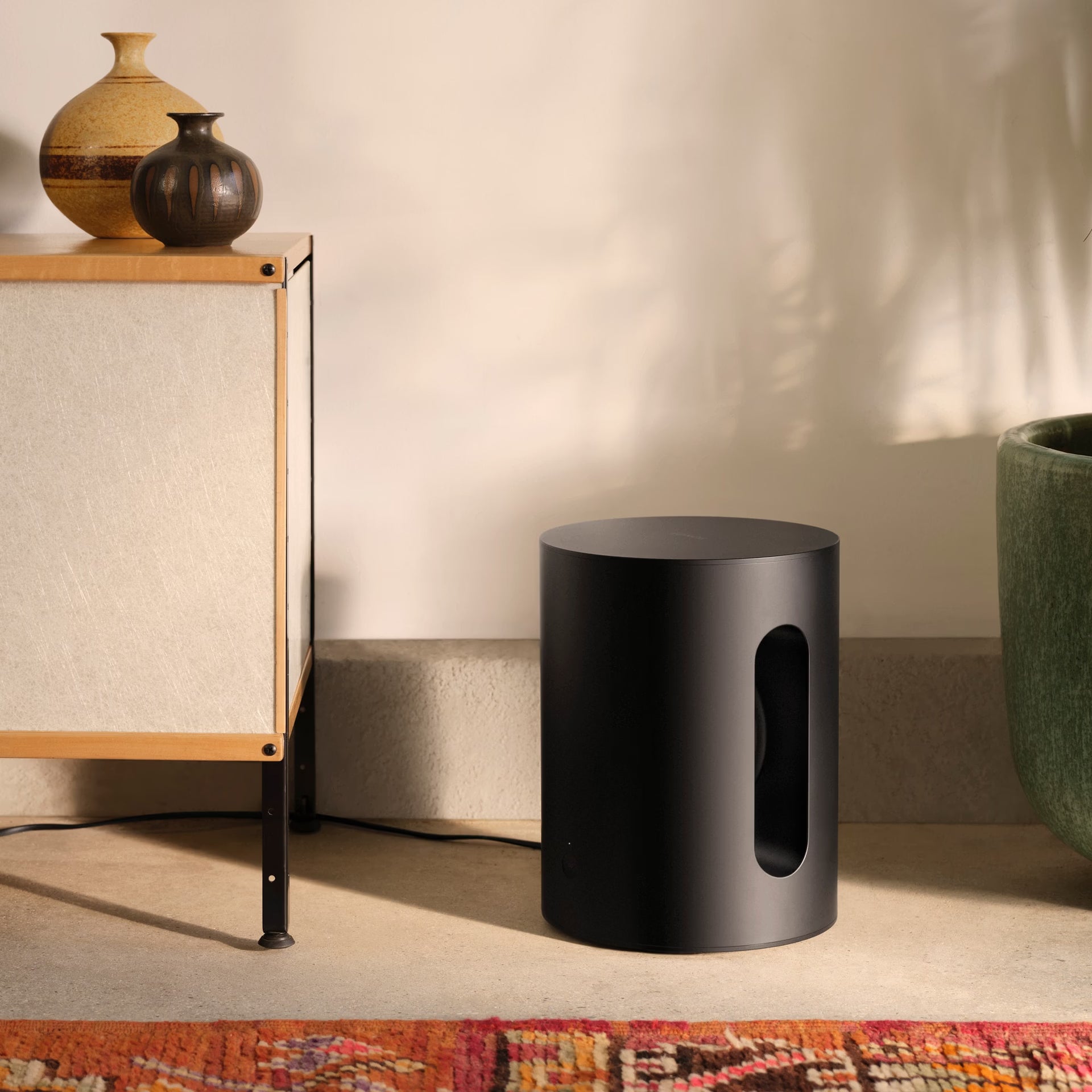 Sonos Sub Mini in black — compact smart subwoofer with cylindrical design for deep, wireless bass