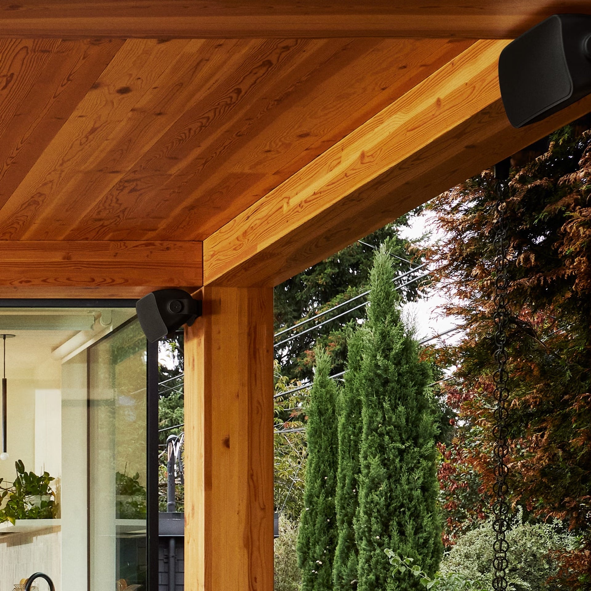 Sonos Outdoor by Sonance black pair in garden — bold custom HiFi weatherproof loudspeakers for outdoor living