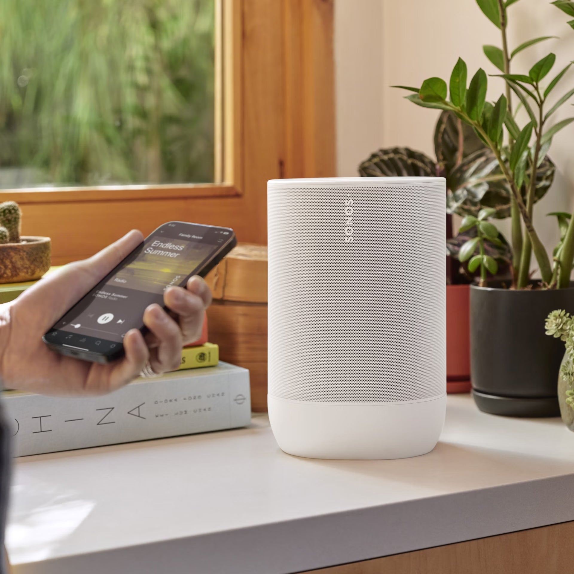 Sonos Move 2 White on a sun-drenched garden terrace delivering powerful HiFi sound