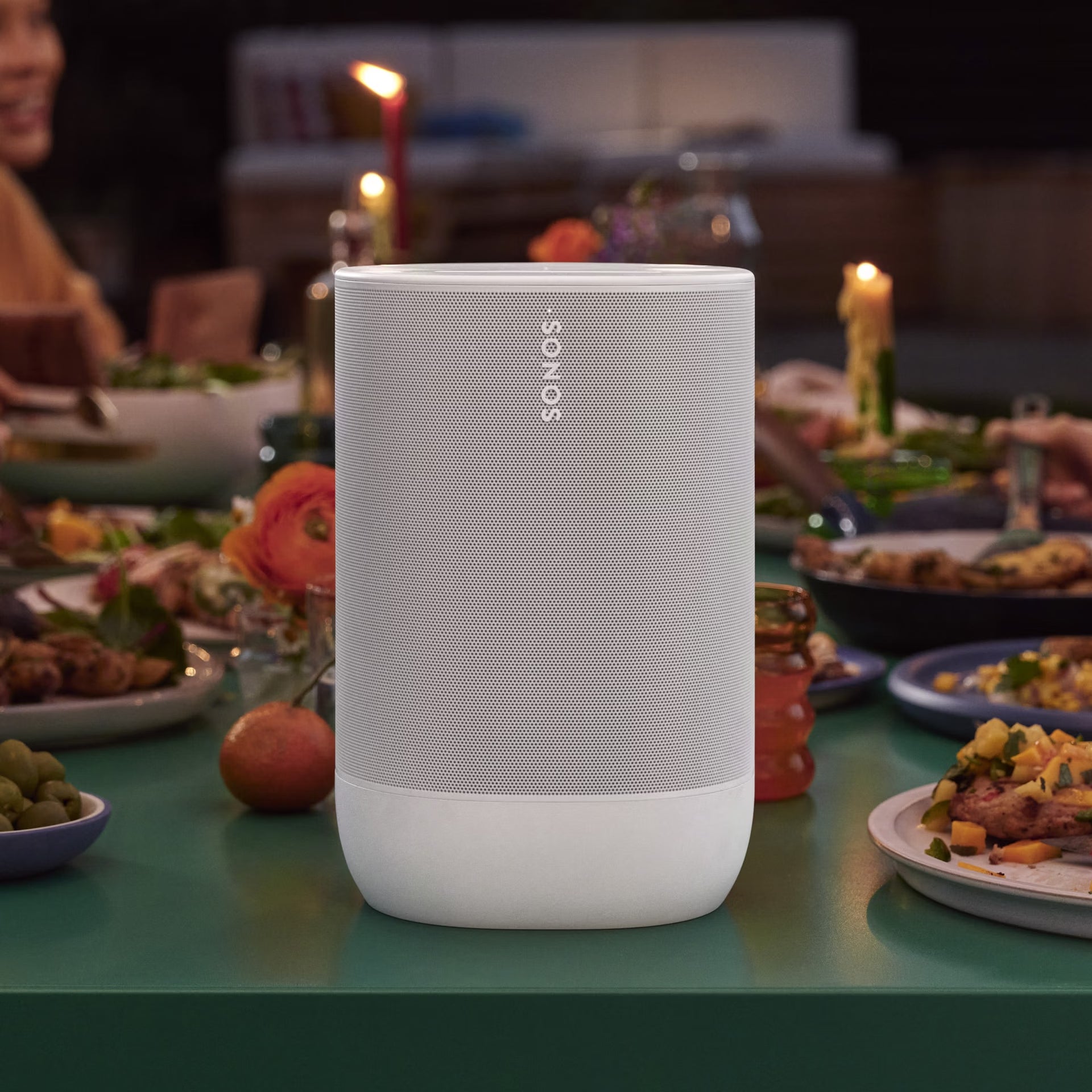 Sonos Move 2 White weatherproof smart speaker poolside for bright on a table with a festive meal in the background