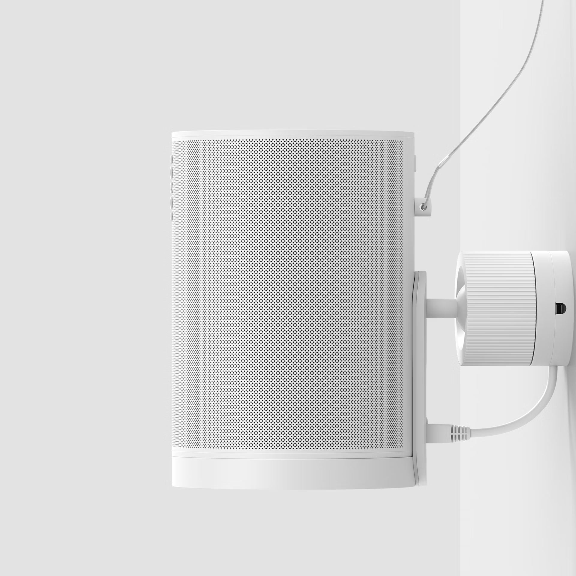 White wall-mounted speaker with a grid pattern on a light gray background