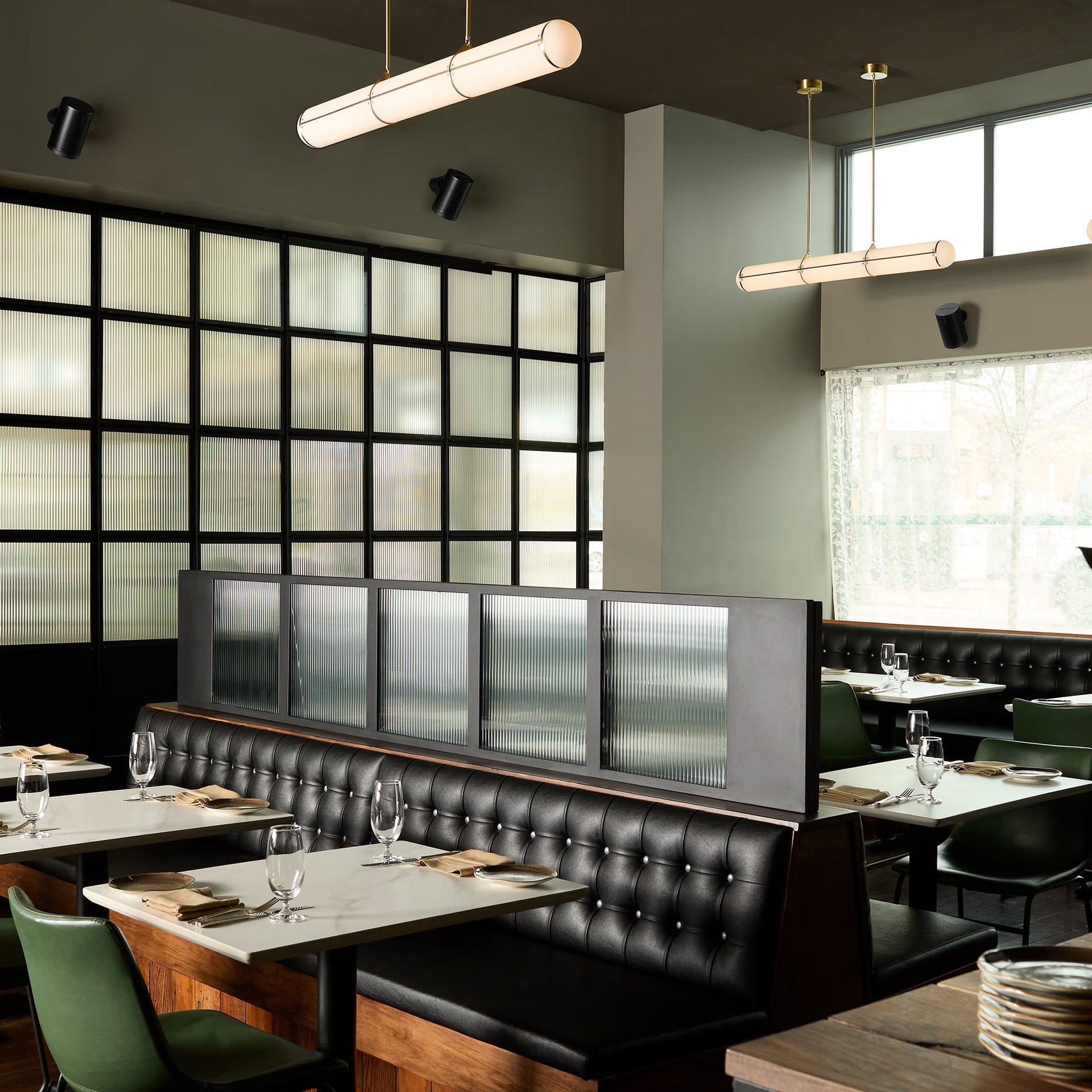 Modern restaurant interior with black leather booths, glass walls,pendant lights and Sonos Era 100 Pro black pair on wall in modern restaurant — HiFi smart loudspeakers for pro stereo audio