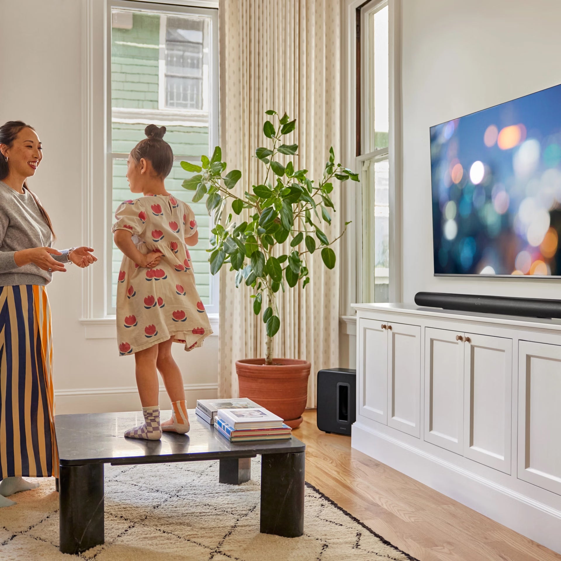 Couple enjoying Dolby Atmos with Sonos Arc Ultra black soundbar — immersive HiFi home cinema experience