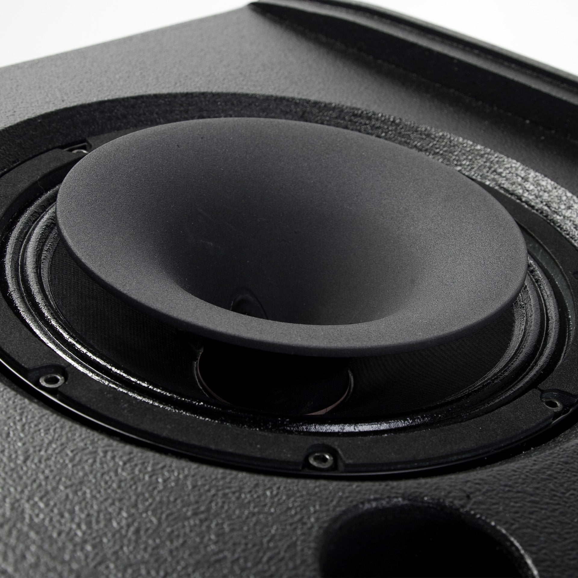 Close-up of a black speaker cone with a white background