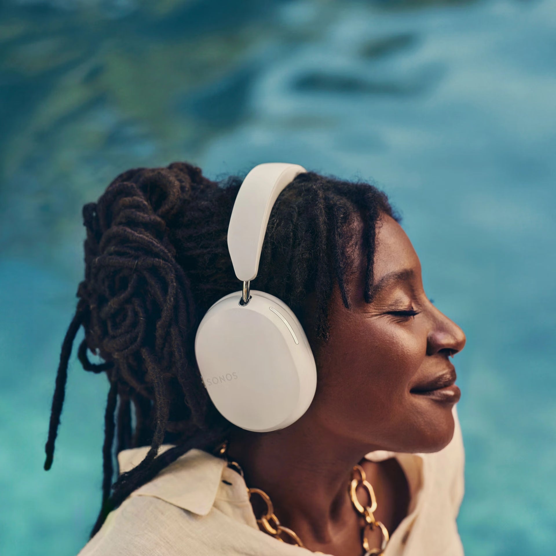 Woman wearing Sonos Ace (White)  headphones with a blurred natural background