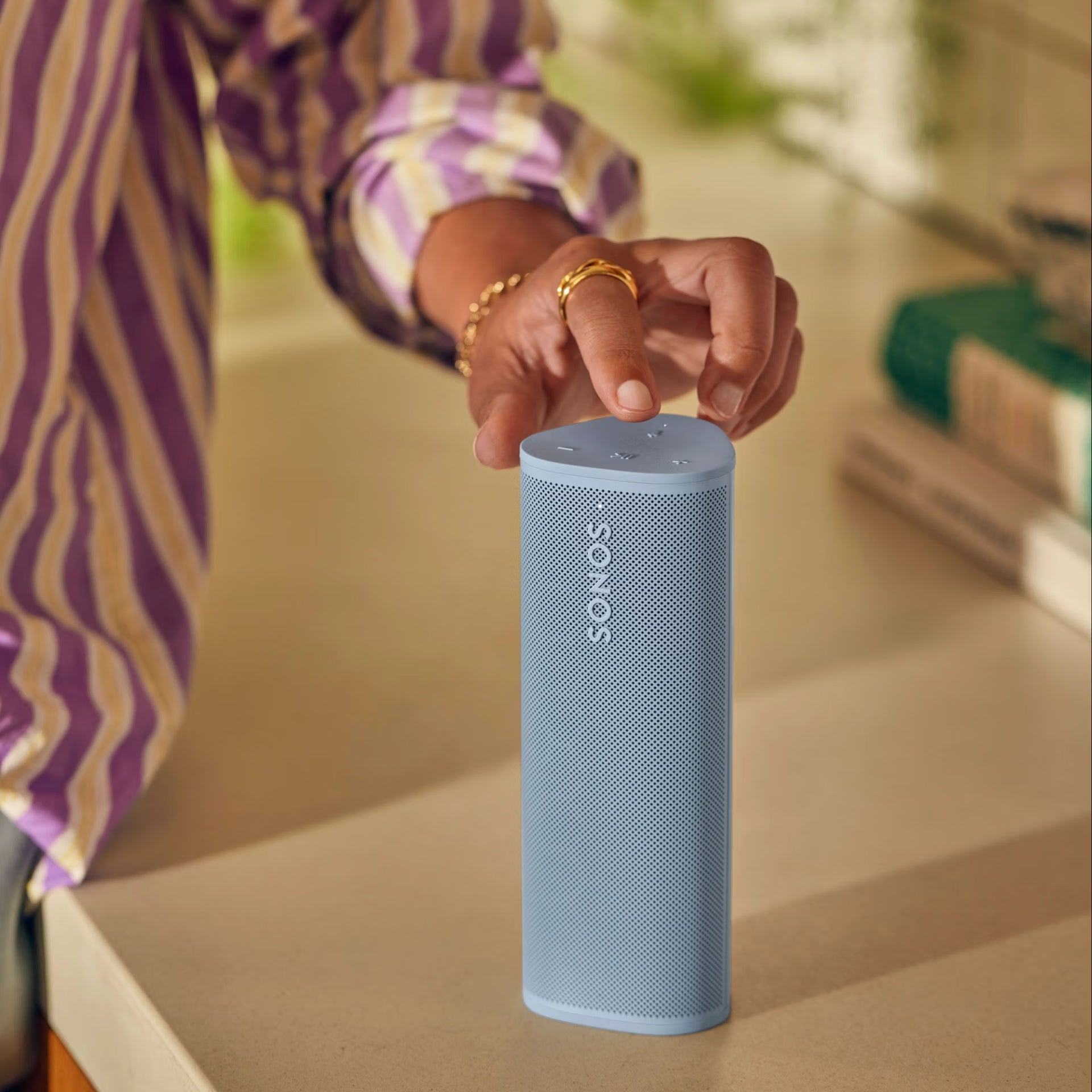 Sonos Roam 2 Blue speaker outdoors on a rock, ideal for hiking and outdoor adventures