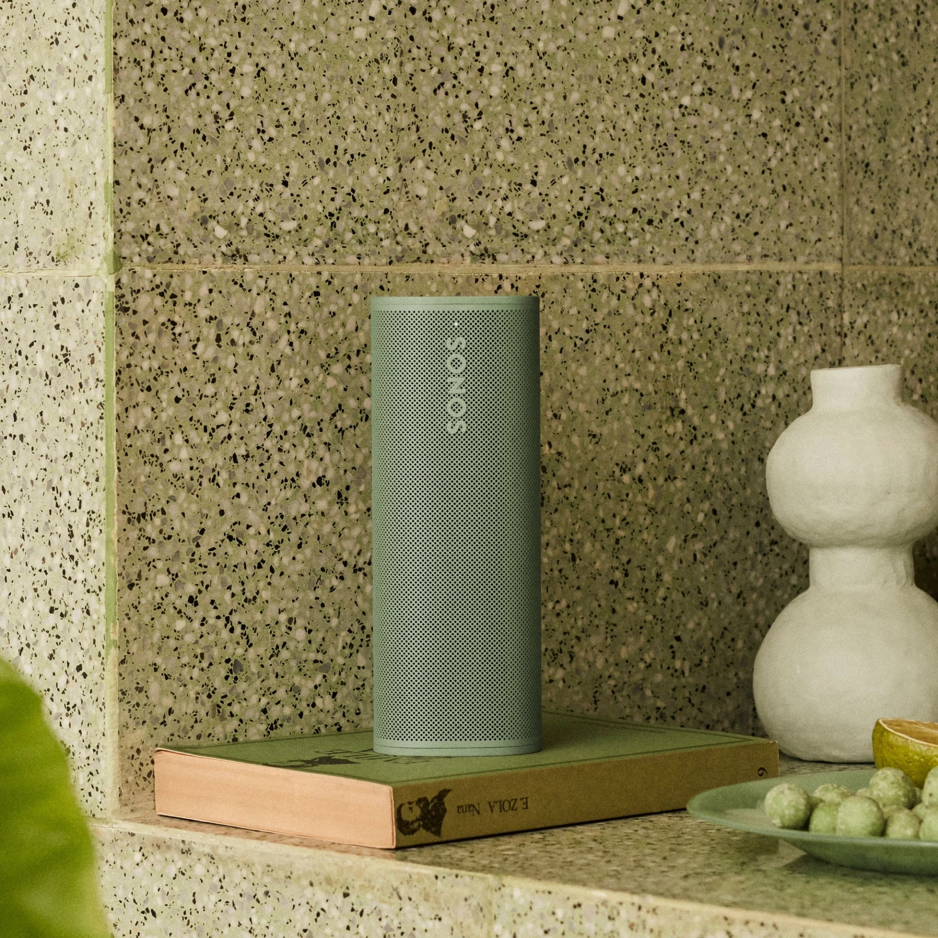 Sonos Roam 2 Green speaker on a forest trail, blending into nature on outdoor adventures