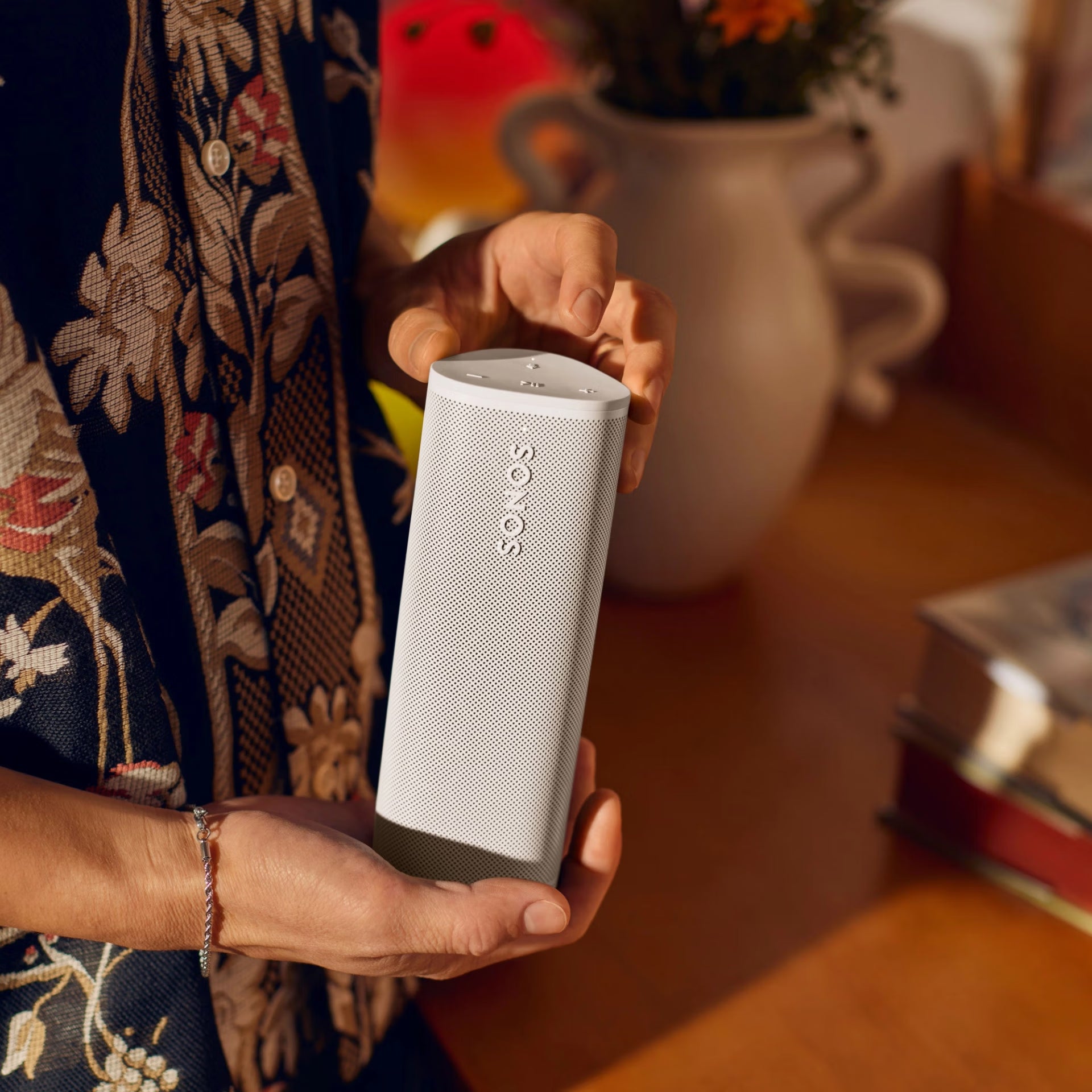 Sonos Roam 2 White voice-enabled smart speaker on a minimalist desk streaming music