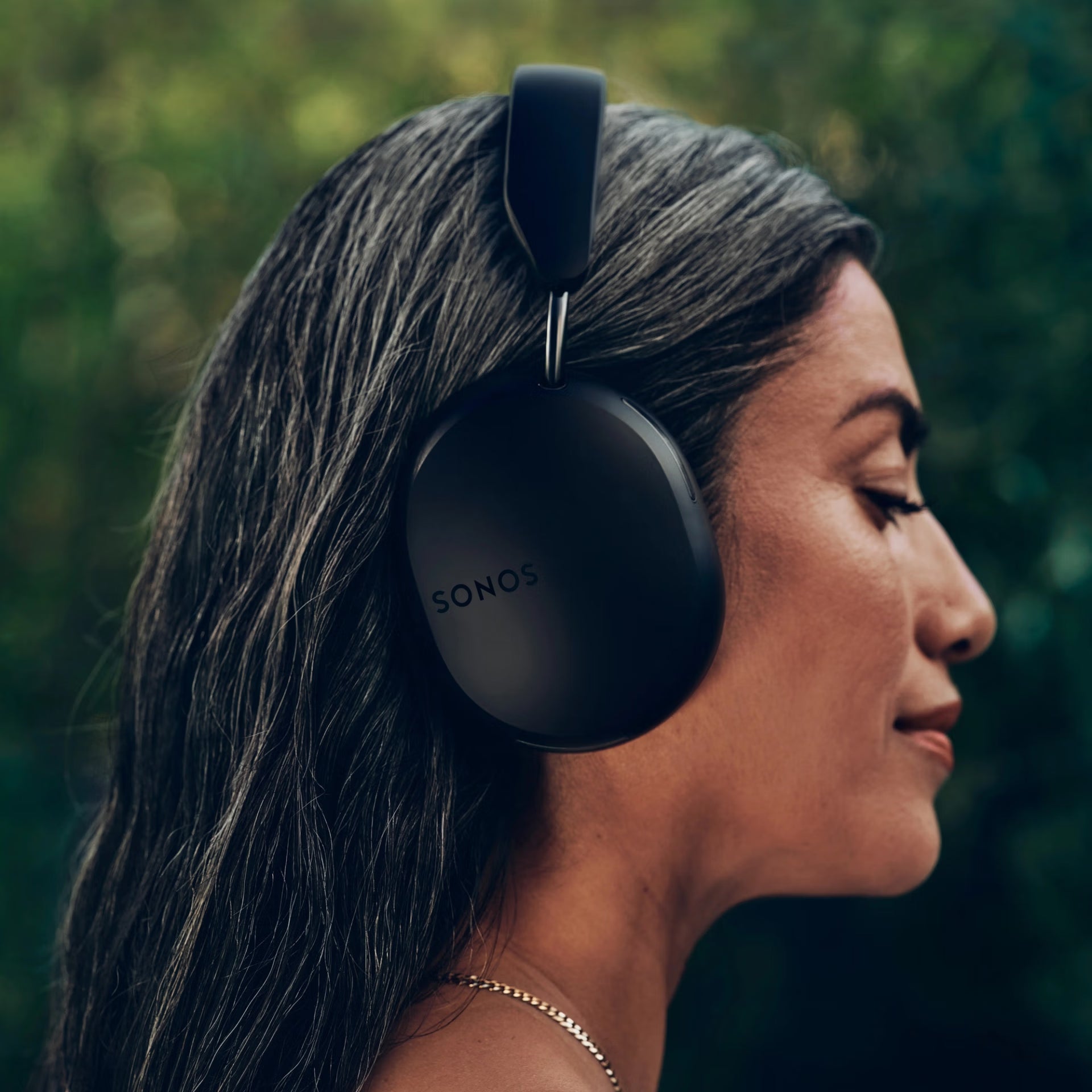Woman wearing SonosAce_Black headphones with a blurred natural background
